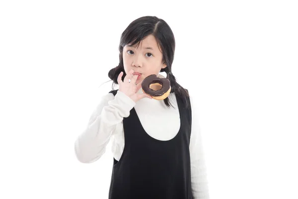 Menina asiática comer donut de chocolate — Fotografia de Stock
