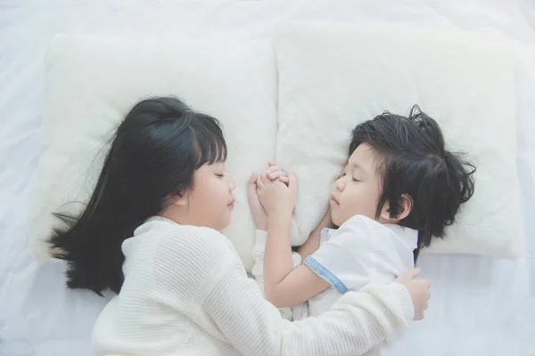 Lindos niños asiáticos tumbados en cama blanca —  Fotos de Stock