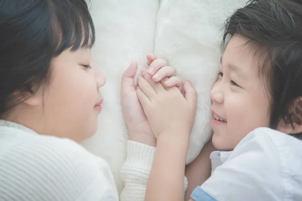 Lindos niños asiáticos tumbados en cama blanca —  Fotos de Stock