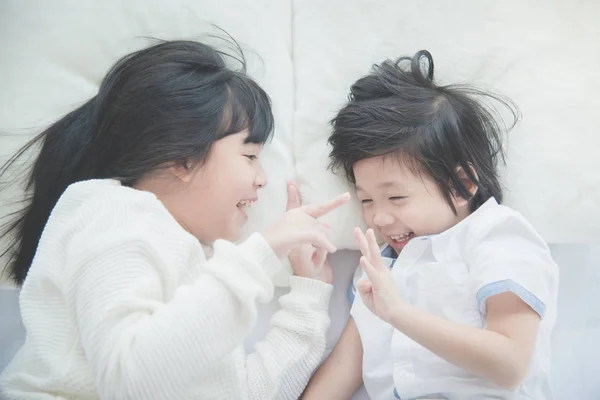 Leuke Aziatische kinderen liggend op witte bed — Stockfoto