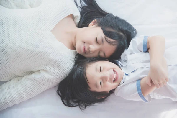 Aranyos ázsiai gyerekek fehér ágyon — Stock Fotó