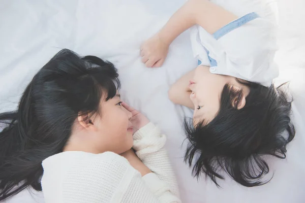 Χαριτωμένο Ασίας παιδιά ξαπλωμένος στο κρεβάτι λευκό — Φωτογραφία Αρχείου