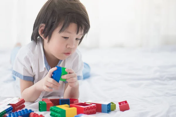 Ασιατικές παιδί που παίζει με το πολύχρωμο κατασκευή μπλοκ — Φωτογραφία Αρχείου