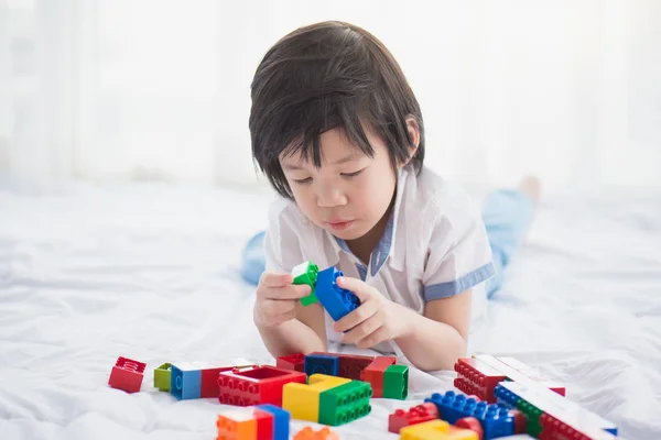 Азиатский ребенок играет с красочными строительными блоками — стоковое фото