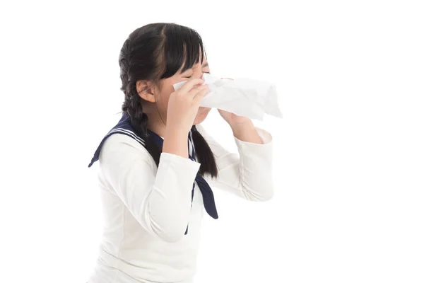 Mooi Aziatisch meisje blaast haar neus op witte achtergrond — Stockfoto