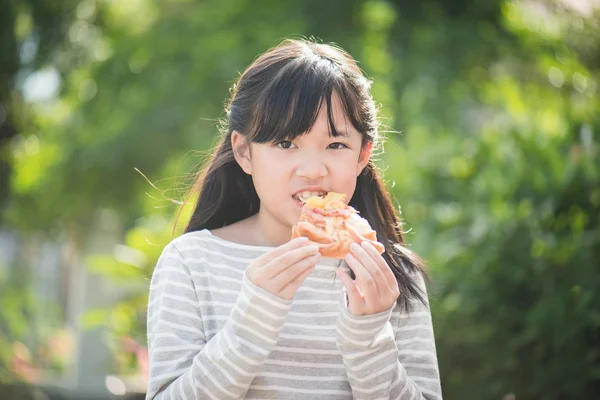 Beautiful Asian girl eating eating pizza — Stock Photo, Image