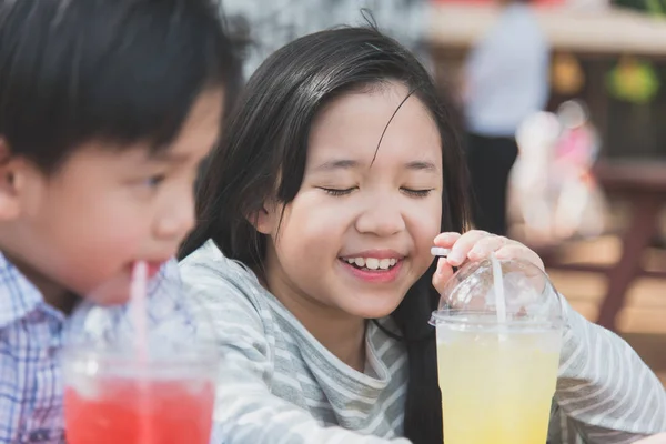 Cute asian children drinking fresh  juice — Stock Photo, Image