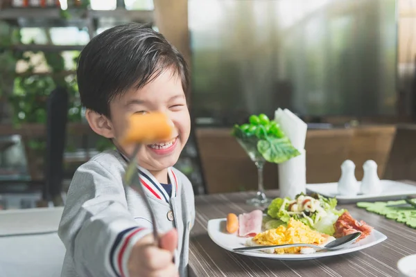 Asian child eating breakfast — Stock Photo, Image