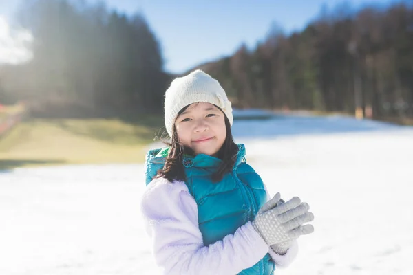 Happy asian girl smiling outdoors in snow on cold winter day — Stock Photo, Image
