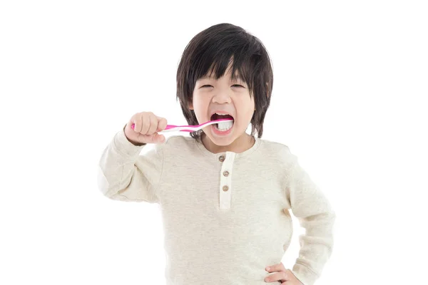 Söta asiatiska pojken tandborstning på vit bakgrund isolerade — Stockfoto