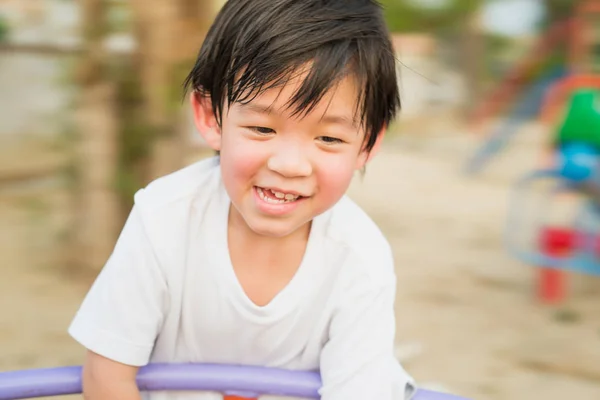 Asian child having fun on carousel — Stock Photo, Image