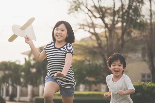 Милий азіатських дітей, що грають картонні літак — стокове фото