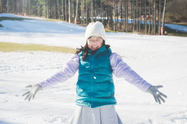 Szczęśliwa dziewczyna Azji uśmiechający się na zewnątrz w śniegu na chłodne zimowe wieczory — Zdjęcie stockowe