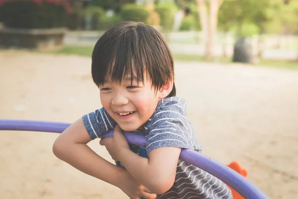 Asian child having fun on carousel — Stock Photo, Image