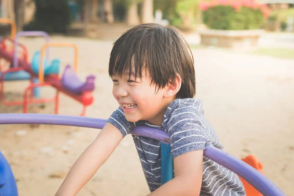 Asiático criança ter diversão no carrossel — Fotografia de Stock
