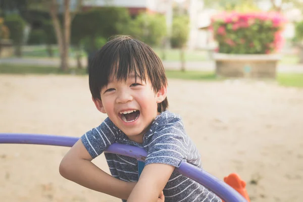 Asian child having fun on carousel — Stock Photo, Image