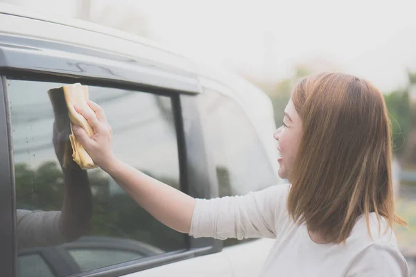 Žena mytí oken automobilů s hadříkem z mikrovlákna — Stock fotografie