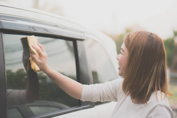 Žena mytí oken automobilů s hadříkem z mikrovlákna — Stock fotografie