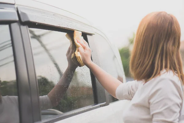 Žena mytí oken automobilů s hadříkem z mikrovlákna — Stock fotografie