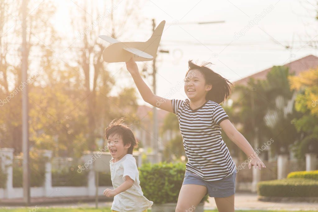 Cute Asian children playing cardboard airplane