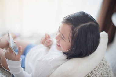 Asyalı kız dinle müzik için kulaklık kullanarak