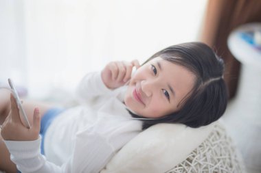 Asyalı kız dinle müzik için kulaklık kullanarak