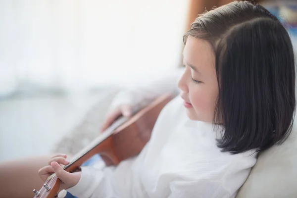 Ásia menina jogar ukulele no — Fotografia de Stock