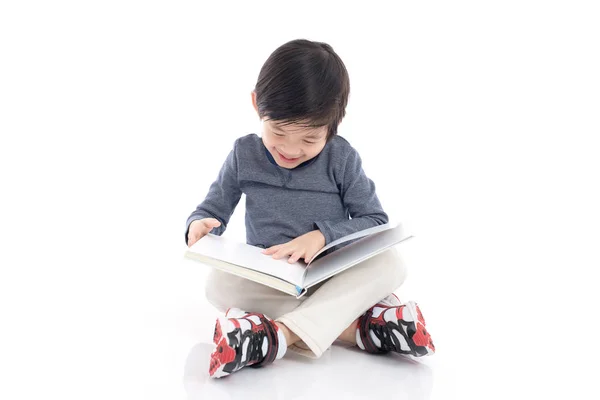 Leuke Aziatische jongen lezen van een boek op witte achtergrond geïsoleerd — Stockfoto