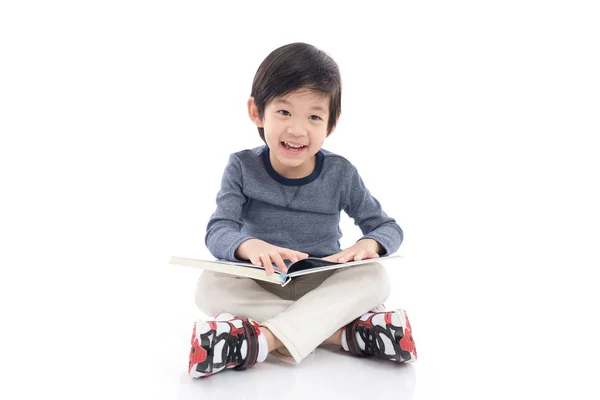 Χαριτωμένο Ασίας αγόρι διαβάζοντας ένα βιβλίο σε άσπρο φόντο απομονωμένες — Φωτογραφία Αρχείου