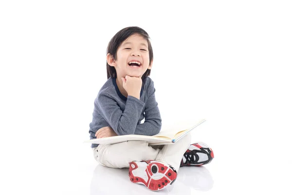 Leuke Aziatische jongen lezen van een boek op witte achtergrond geïsoleerd — Stockfoto