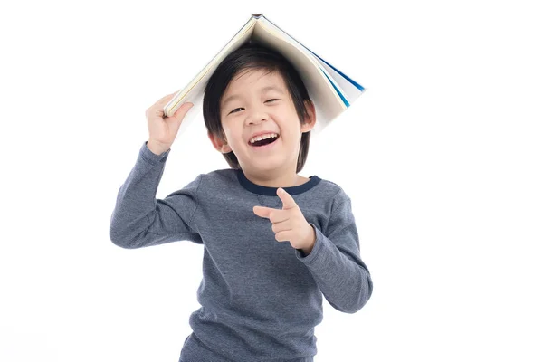 Asiatico ragazzo con libro su testa — Foto Stock