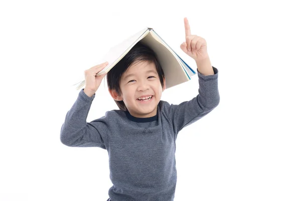 Aziatische jongen met boek op hoofd — Stockfoto