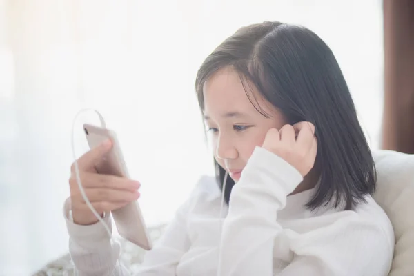 Asiática chica usando auricular para escuchar música —  Fotos de Stock