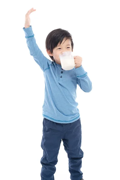 Aziatische jongen die melk drinken van een glas op witte achtergrond — Stockfoto