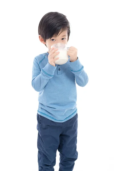 Asiático chico bebiendo leche de un vaso en blanco fondo —  Fotos de Stock