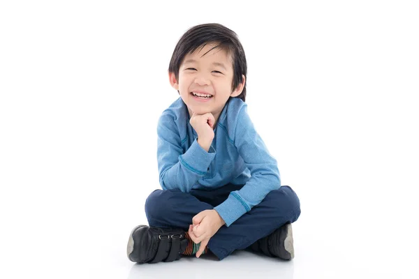 Азиатский мальчик сидит на белом фоне — стоковое фото