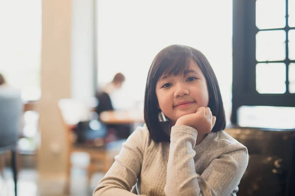 Retrato de la hermosa chica Adsian sonriendo en una cafetería —  Fotos de Stock