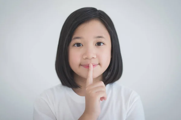 Beautiful Adsian girl with a finger on her lips — Stock Photo, Image