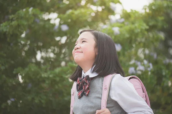 Красивая азиатская школьница с розовым рюкзаком смотрит вверх — стоковое фото