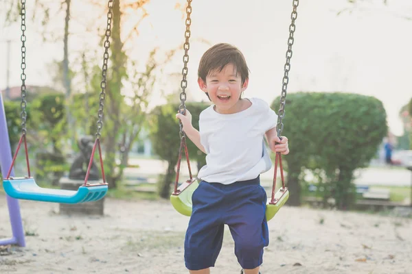 Asiatiska barn som leker på swing — Stockfoto