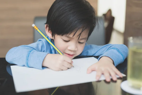 アジアの子が白い紙に書く — ストック写真