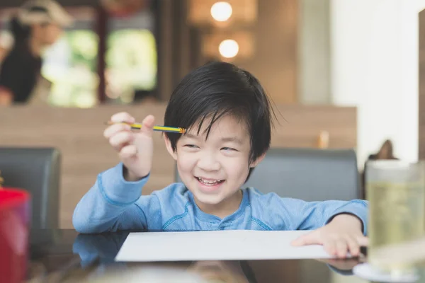 Asiatiska barn skriver på vitt papper — Stockfoto