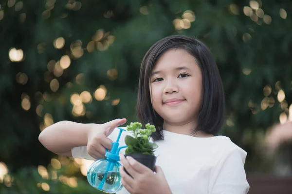 Asiatisk tjej vattning en röd blomma i trädgården — Stockfoto