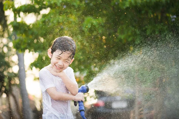 Asiatiska boy har roligt att spela i vatten — Stockfoto