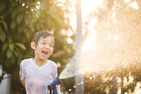 Asian boy has fun playing in water — Stock Photo, Image