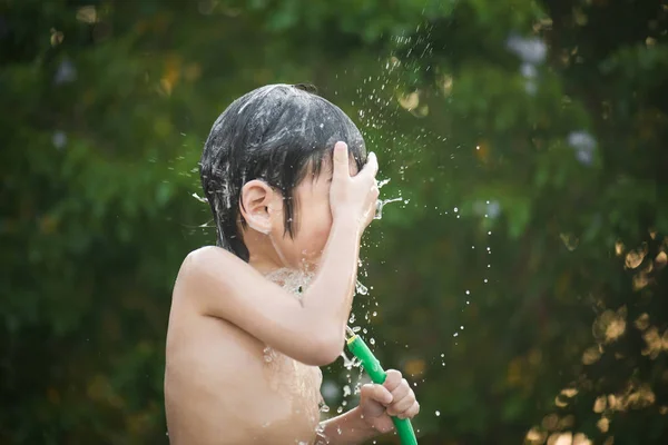 Asiatiska boy har roligt att spela i vatten — Stockfoto