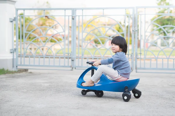 야외에서 파란색 장난감 자동차를 운전 하는 아시아 아이 — 스톡 사진