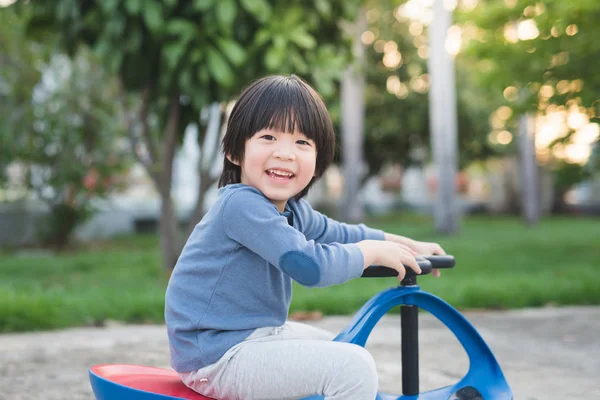 Asiatique enfant conduite jouet bleu voiture en plein air — Photo