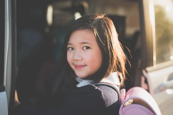 Азиатка в студенческой форме едет в школу на машине — стоковое фото