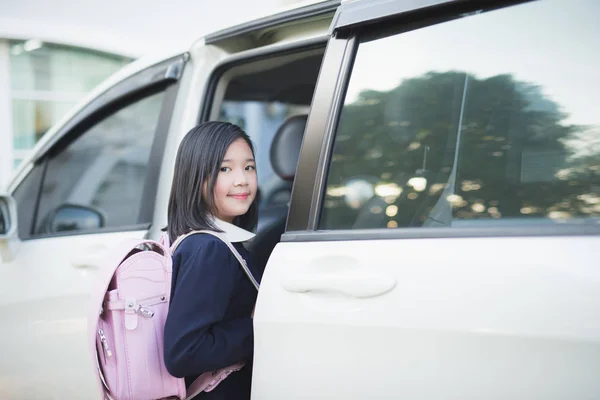Menina asiática em uniforme de estudante indo para a escola de carro — Fotografia de Stock